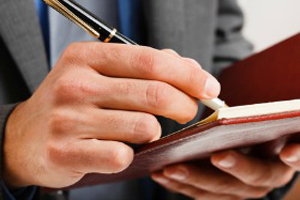 Detail of a businessman writing on his agenda Businessman writing on his agenda