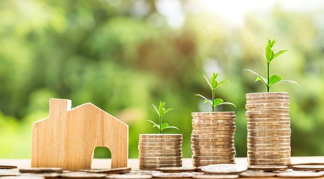 Coins and model house to represent property prices