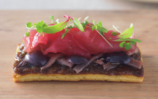 Pissaladière with baby leaves and soused tuna